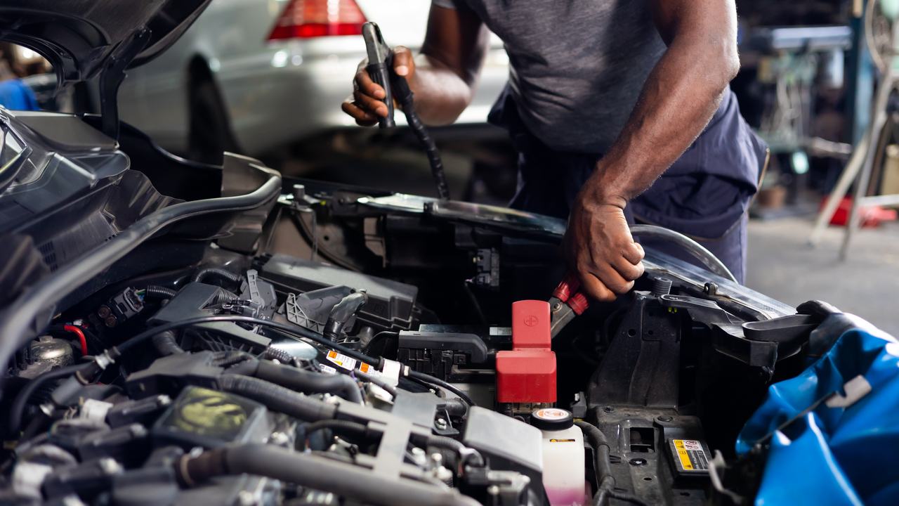 A specialist working on a European car in a workshop bay
